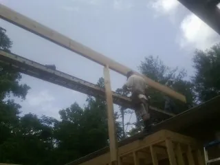 Carpenter setting a ridge beam over a new addition frame — Ice Dam Removal by Roofing Brothers in North Grafton