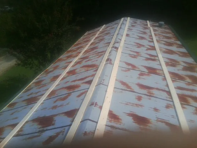 Rusted metal roof panels with new wood purlins before replacement — Storm Damage Roof Repair in North Grafton by Roofing Brothers