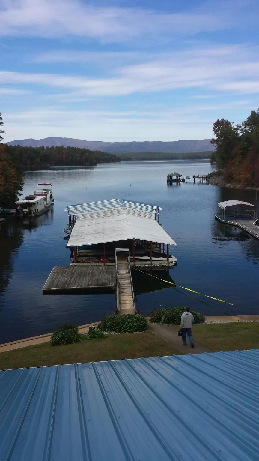 View across a lake from a newly installed blue metal roof in North Grafton